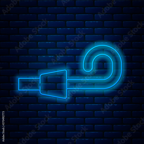 Glowing neon line Birthday party horn icon isolated on brick wall background. Vector.