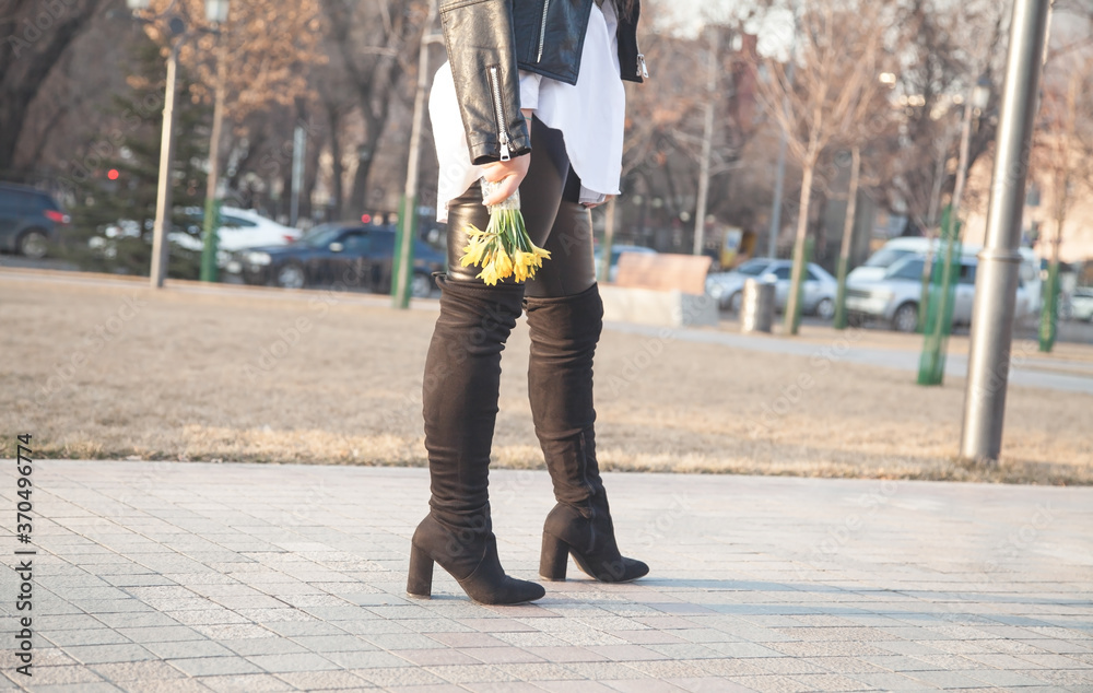 Obraz premium Caucasian young girl holding yellow flowers in outdoors.