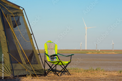 Camping rest. Turbine of a wind power generator on a background of blue sky. Alternative energy sources.