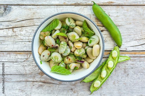 A healthy rich protein salad made from broad beans and fresh herbs. Vegetarian food.