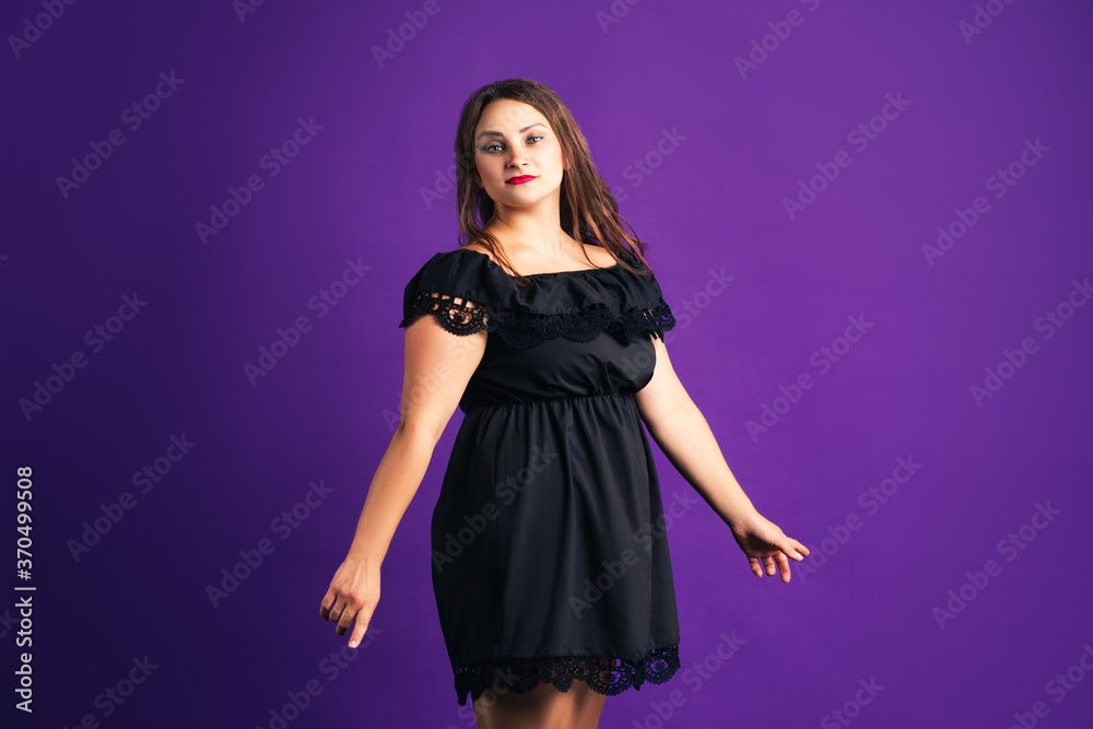 Plus size fashion model in black dress, fat woman on purple background Plus size fashion model in black dress, fat woman on purple background