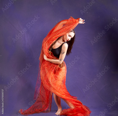 Fototapeta Naklejka Na Ścianę i Meble -  a white nice and fit girl, dancing with orange sash.