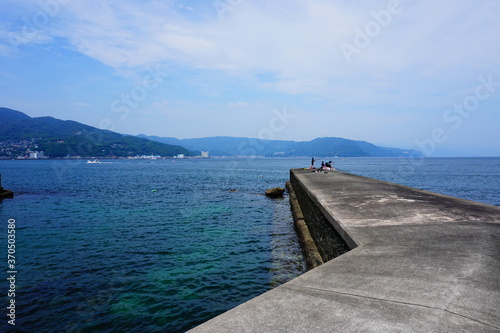 Tableau sur toile 伊東の小さな堤防で釣りや海水浴を楽しむ人々