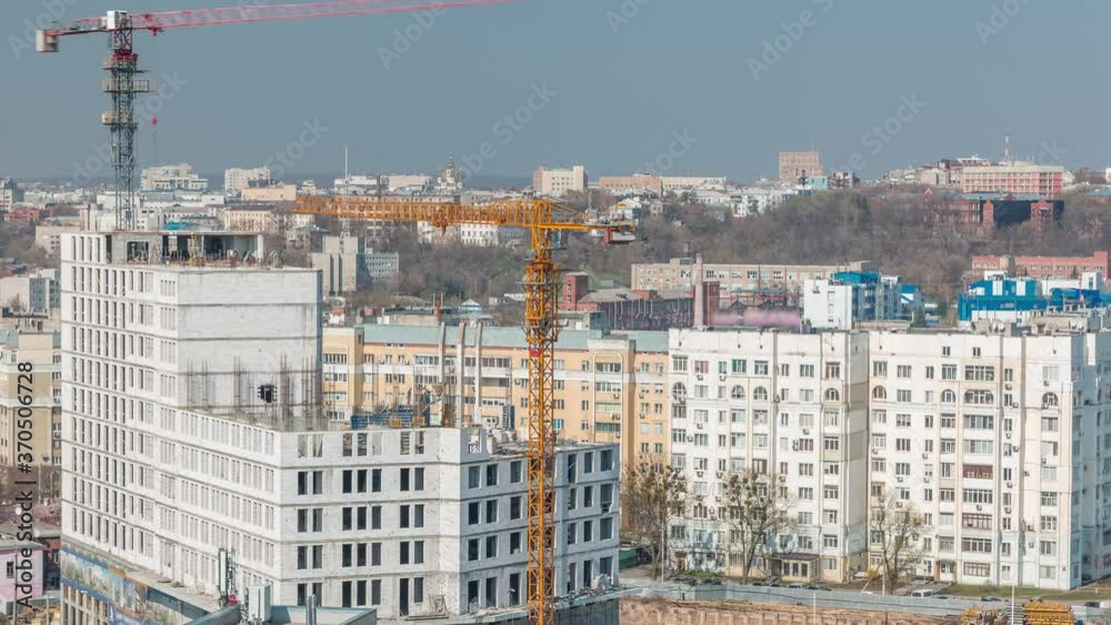 Construction site with lots of yellow cranes next to the road timelapse, aerial view. Building new residential complex in Kharkov, Ukraine Construction site with lots of yellow cranes next to the road timelapse, aerial view. Building new residential complex in Kharkov, Ukraine