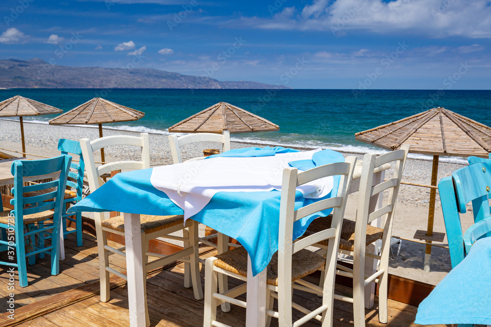 Empty restaurant tables at the Maleme beach on Crete, Greece
