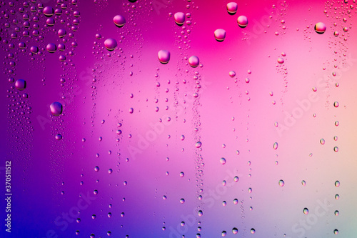 Water droplets on glass surface. Colorful blurred abstract of water drops texture on pink magenta background