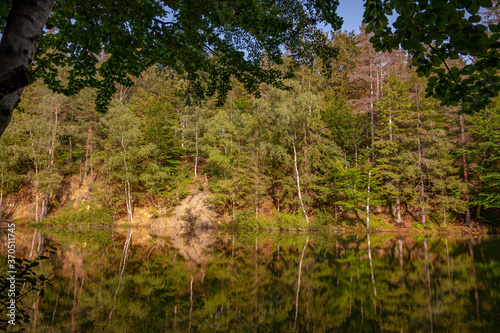 Natural colorful lakes in Europe. "Kolorowe Jeziorka" in Rudawy Janowickie, Poland. Beautiful lake with reflection against forest.