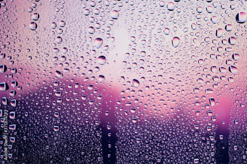 Water droplets condensed on the glass surface in the evening. View through the window in the rainy season