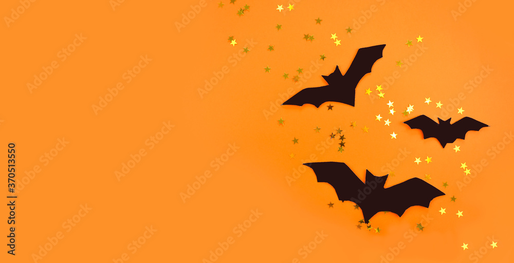 Minimalist Halloween composition with decorative bats and confetti on orange background. Mock up holiday design for party or sale. Top view, copyspace. Minimalist Halloween composition with decorative bats and confetti on orange background. Mock up holiday design for party or sale. Top view, copyspace.