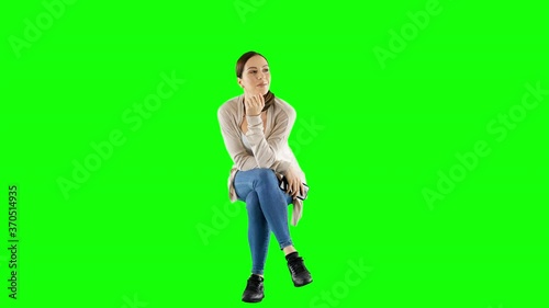 Smiling Young Woman in Casual Clothes Sitting and Waving To Friend Green Screen