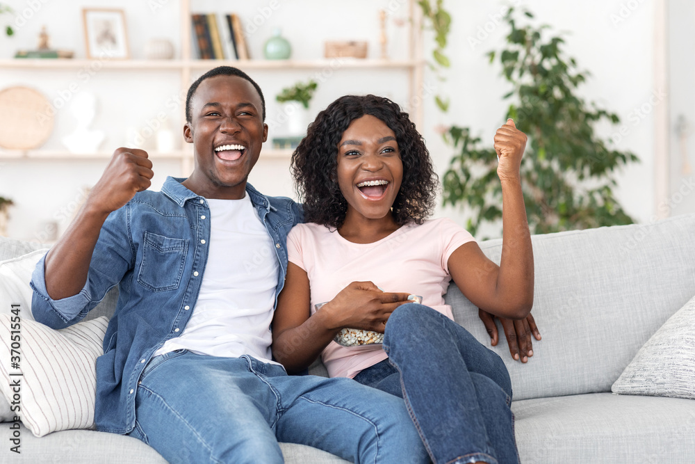 Emotional black couple watching football game at home Emotional black couple watching football game at home