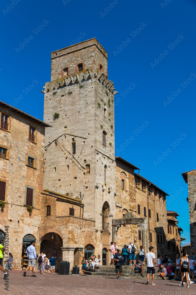 Nice portrait shot of la torre del Diavolo in San Gimignano, Tuscany. The tower at the northern side of the Piazza della Cisterna stands next to the cistern, capped by a travertine octagonal pedestal.