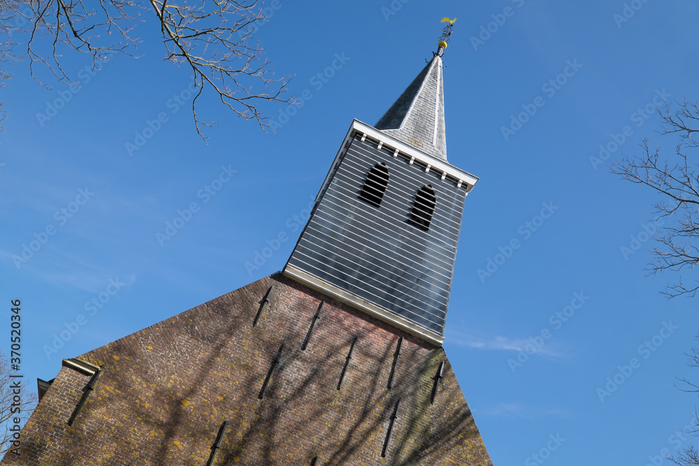 Φωτογραφία Tower of the church in the little village Tjerkgaast, Friesland, The Netherlands at blue sky