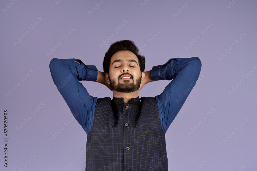 Portrait of young Indian man with closed eyes having rest on violet background Portrait of young Indian man with closed eyes having rest on violet background