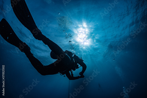 silhouette of scuba diver underwater in ocean 