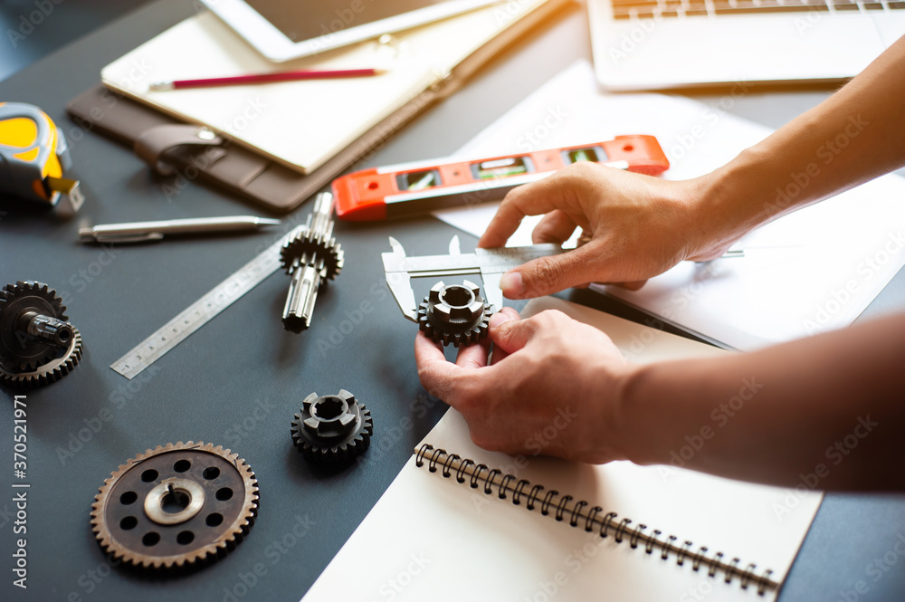 Engineers work to measure the gear model to design the mechanism of