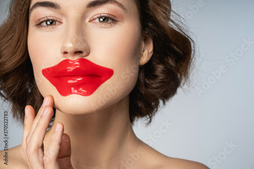 Beautiful young woman using crystal collagen lip patch