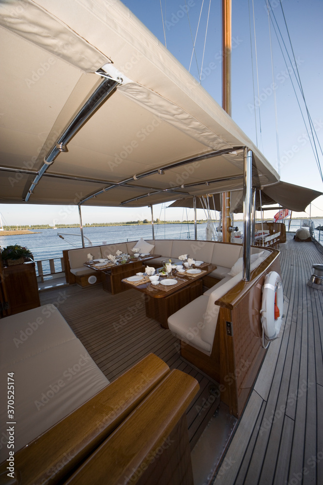 Deck of a classic wooden sailing yacht. Netherlands. Dinner table laid.