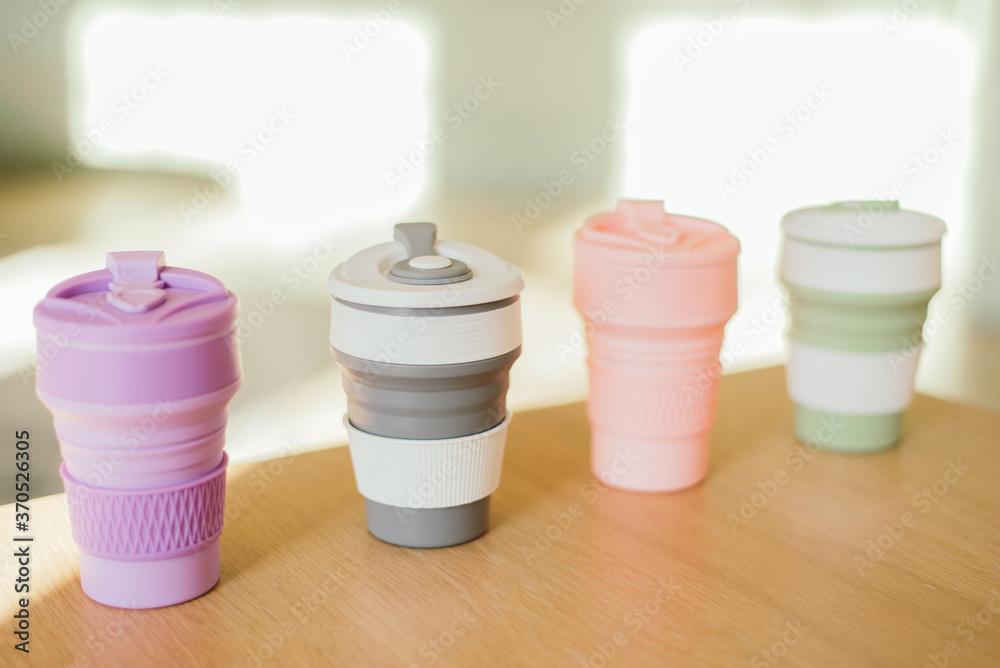 A set of multi-colored folding silicone cups for drinks without plastic in a waste-free style on the background of the interior, close-up. Product photography. Store content A set of multi-colored folding silicone cups for drinks without plastic in a waste-free style on the background of the interior, close-up. Product photography. Store content