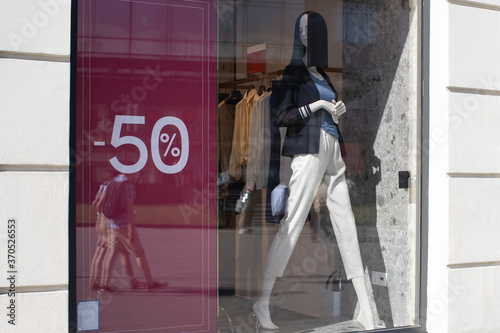 Showcase of clothing store in season of discounts, mannequin in modern comfortable women's clothing, banner with inscriptions of discount 50 percent. Concept shopping, black friday, sales. Horizontal