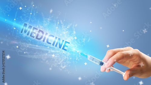 Syringe, medical injection in hand with MEDICINE inscription, medical antidote concept