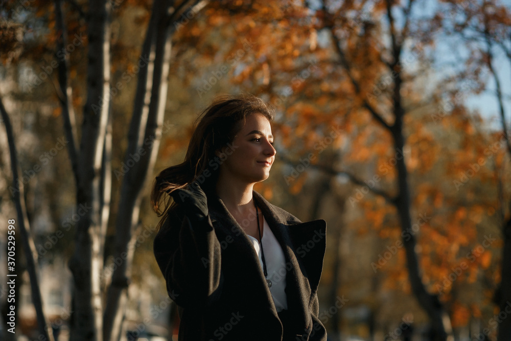 Outdoor fashion photo of young beautiful lady in red scarf and dark grey coat surrounded autumn landscape. Outdoor fashion photo of young beautiful lady in red scarf and dark grey coat surrounded autumn landscape.