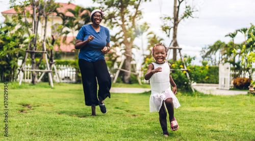 Portrait of enjoy happy love black family african american mother and little african girl child smiling running and having fun moments good time in summer park at home