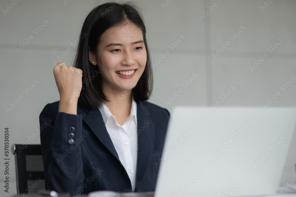 Young beautiful Asian business woman felling happy or success after look at notebook computer. Business successful concept. Young beautiful Asian business woman felling happy or success after look at notebook computer. Business successful concept.
