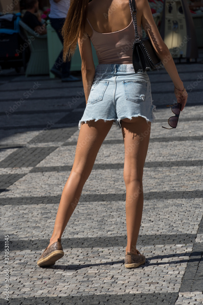 Prague, Czech Republic - July 23, 2020: Cropped image of a beautiful woman in shorts, rear view Prague, Czech Republic - July 23, 2020: Cropped image of a beautiful woman in shorts, rear view
