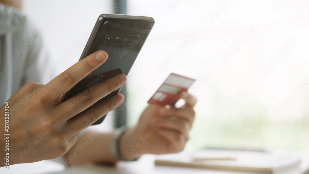 Shopping online with smartphone and credit card on hand Shopping online with smartphone and credit card on hand
