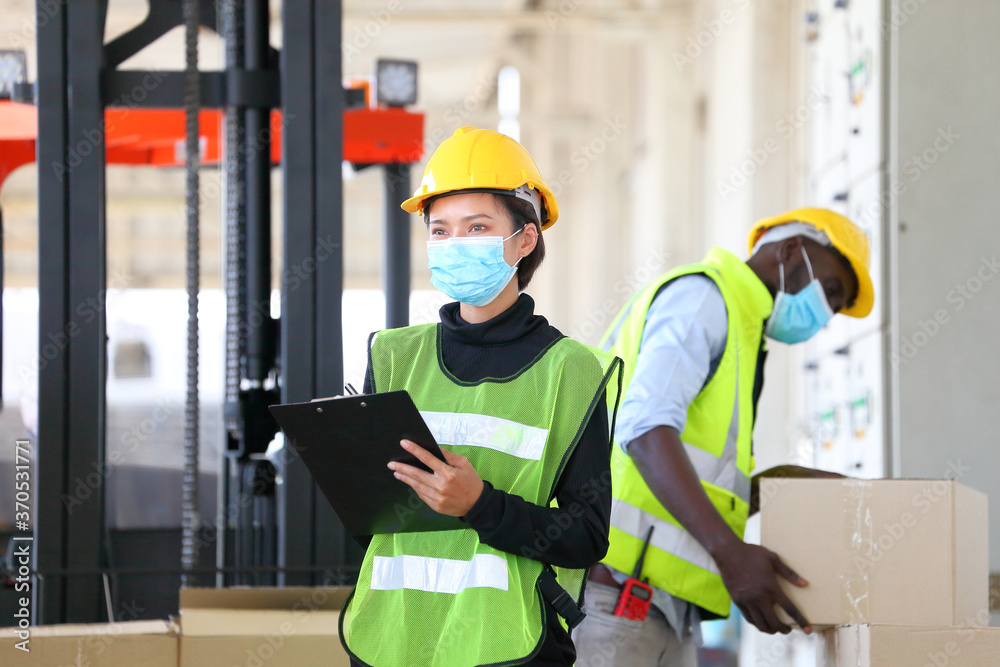 Foto de Asian and African American workers wearing facial mask and ...