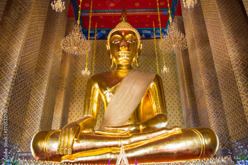 Big golden statue of sitting Buddha in famous buddhist temple. Wat Kanlayanamit, Bangkok, Thailand