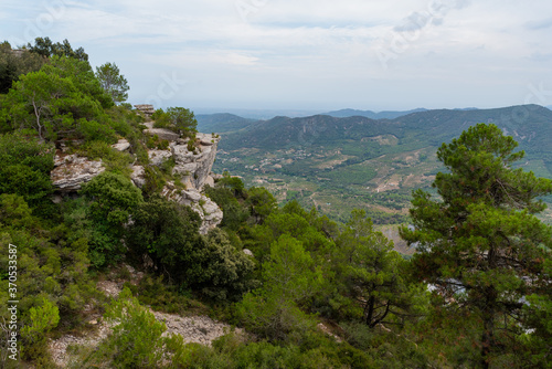 View of a mountain landscape in the Prades area in Catalonia with green and blue tones of the sky and clouds