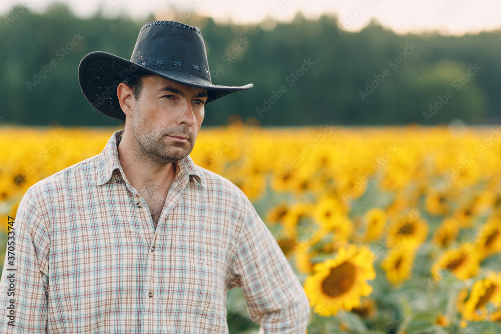Man farmer standing in a sunflower field