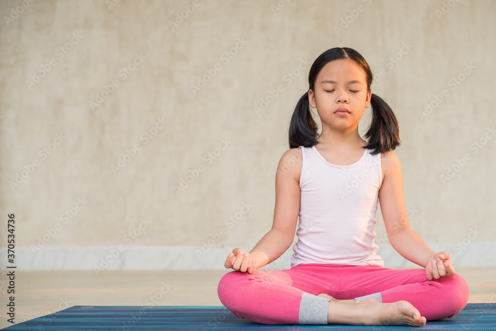 calmness and relax, female freedom happiness. home practice room background. little asian girl meditates while practicing yoga. child happiness. toned picture healthy life. yoga concept. calmness and relax, female freedom happiness. home practice room background. little asian girl meditates while practicing yoga. child happiness. toned picture healthy life. yoga concept.