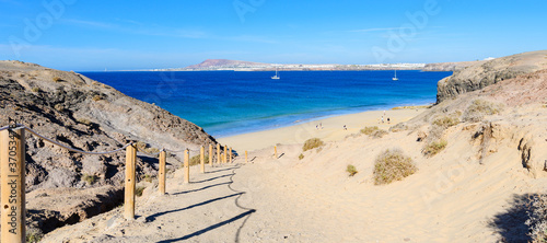 View of beautiful Playa de la Cera beach, from above, blue sea, yellow sand, cliffs. Papagayo, Playa Blanca, Lanzarote, Canary Islands, selective focus photo