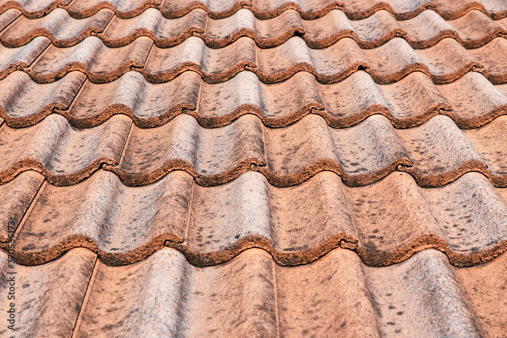 Close up of brown clay roof tiles. Red old dirty roof. Old roof tiles. Construction equipment build a house.