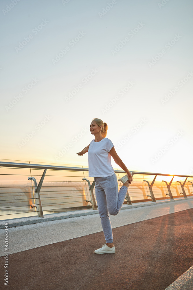 Sporty Caucasian woman stretching her leg muscles