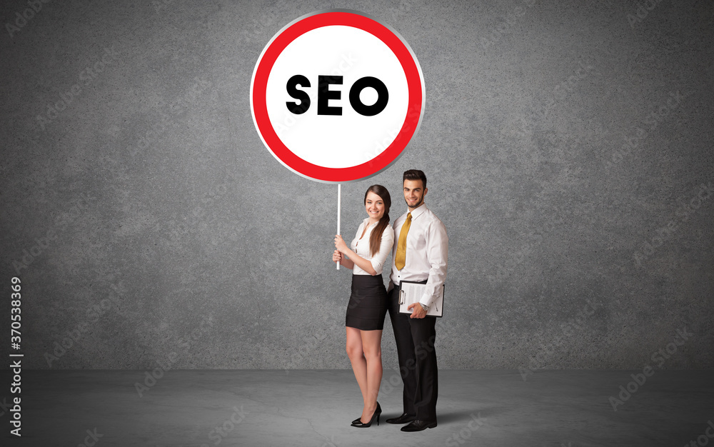 Young business person holdig traffic sign with SEO abbreviation, technology solution concept Young business person holdig traffic sign with SEO abbreviation, technology solution concept