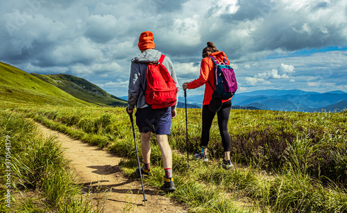 Fototapeta Naklejka Na Ścianę i Meble -  Hiking couple in the mountains. Mountain landscape on the summer. Mountain landscape in Poland Bieszczady.
