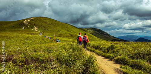 Fototapeta Naklejka Na Ścianę i Meble -  Hiking couple in the mountains. Mountain landscape on the summer. Mountain landscape in Poland Bieszczady.