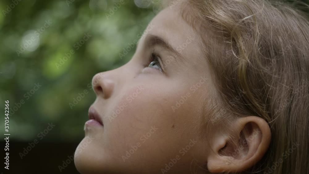 Kid Looking Up at Sky in Nature. Portrait Little Girl Praying Looking Up at Sky With Hope and Faith, Contemplative Child Face, Closeup. Girl Looks-up God Believer Prayer, Passionate Dreamer Divine.