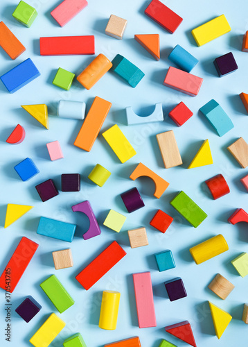 Wooden colorful cubes on a light blue background. View from above. Construction.