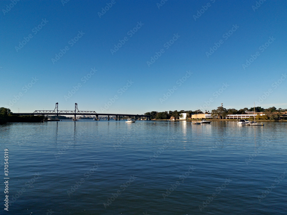 Beautiful view of high-rise buildings on the riverbank on a sunny day with deep blue sky, Parramatta river, Meadowbank, Sydney, New South Wales, Australia