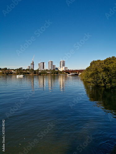Beautiful view of high-rise buildings on the riverbank on a sunny day with deep blue sky  Parramatta river  Meadowbank  Sydney  New South Wales  Australia