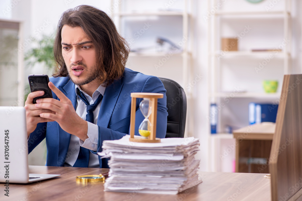 Young male employee unhappy with excessive work Young male employee unhappy with excessive work