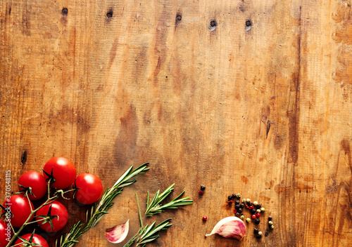 Food ingredients on old wooden background. Herbs and tomatoes. Healthy concept. Top view. Flat lay