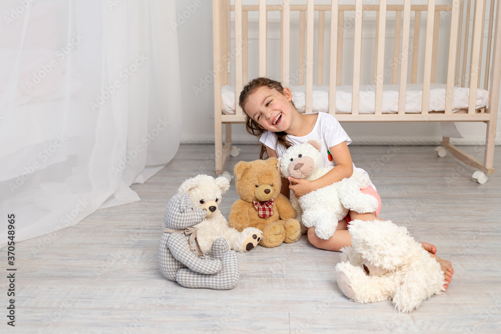 little girl 5-6 years old playing in the children's room with Teddy bears little girl 5-6 years old playing in the children's room with Teddy bears