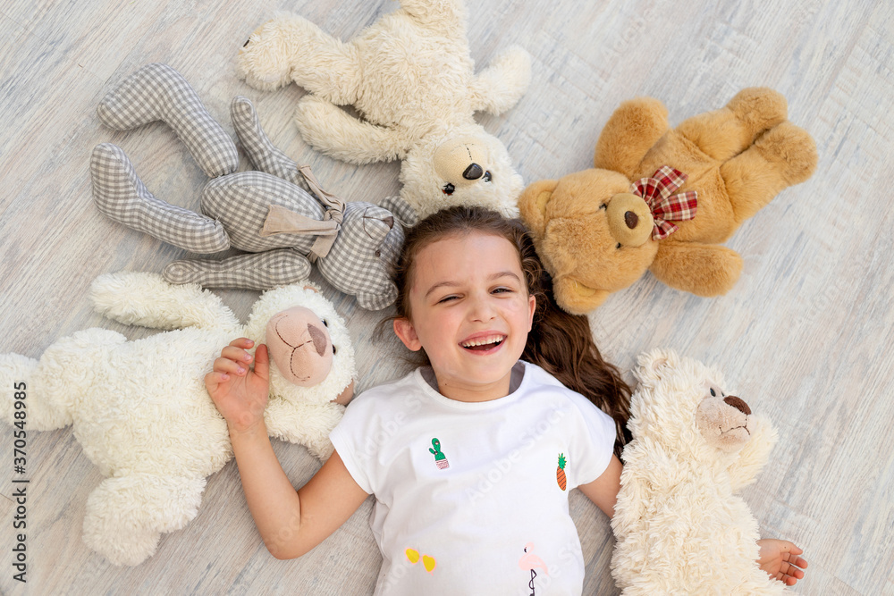 a little girl 5-6 years old lies among Teddy bears a little girl 5-6 years old lies among Teddy bears
