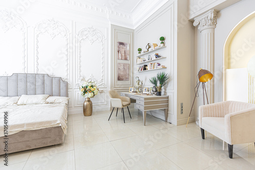 chic luxury interior in an old antique style open-plan apartment decorated with columns and stucco on the wall in pastel colors. tiles on the floor. beige walls